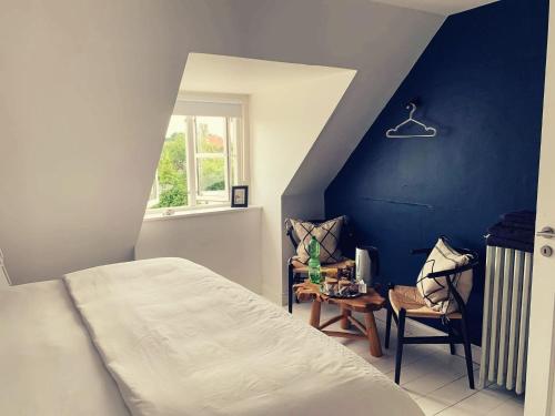 a bedroom with a bed and a blue wall at Room in a Danish cottage with garden view, 10 min to CPH in Gentofte