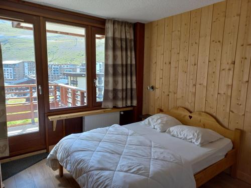 une chambre avec un lit et une grande fenêtre dans l'établissement Appartement 2 pièces, sud-ouest, montagne, Tignes - FR-1-449-7, à Tignes