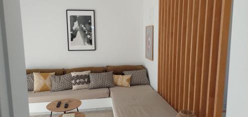 een woonkamer met een bruine bank met kussens bij Apartamento 90m2 com vista mar - Albufeira in Albufeira