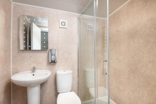 a bathroom with a toilet and a sink and a shower at Four Oaks House in Carlisle