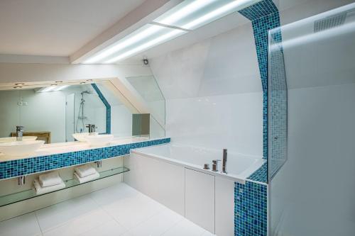 a bathroom with two sinks and a mirror at Makom Pereire in Paris