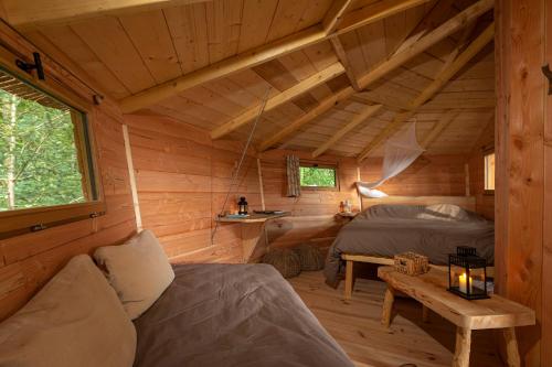 a room with two beds in a log cabin at Cabanes de la Grande Noe in Les Épasses