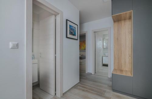 korytarz z białymi ścianami i drewnianą podłogą w obiekcie Apartment Sunshine w mieście Klimno