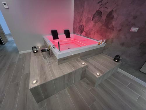 a pink bathtub with black chairs in a room at Pegasus Hotel in Sassari