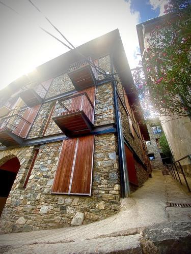 a building with wooden doors on the side of it at CAL DOMÈNEC RIALP - Dúplex con encanto - Se admiten mascotas in Rialp