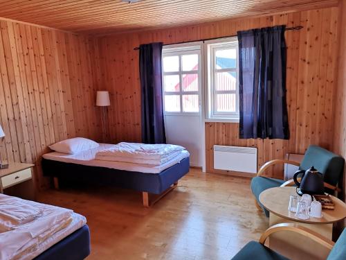 um pequeno quarto com 2 camas e uma janela em Statles Rorbu- og Konferansesenter AS em Leknes