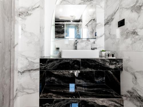 a black and white bathroom with a sink and a mirror at Boheme Villas close access to Laganas Resort in Zakynthos Town