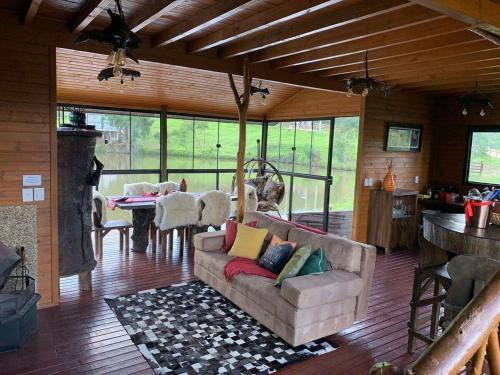 a living room with a couch and a table at Pousada Cachoeira da Neve- Chalé Quero Quero in Urubici