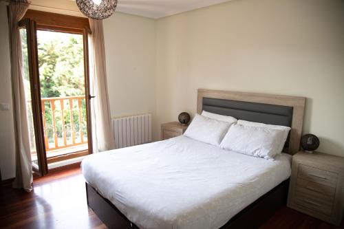1 dormitorio con cama y ventana grande en Tu casa, en Casasola