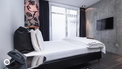 een slaapkamer met een wit bed en een raam bij Thingholt by Center Hotels in Reykjavík