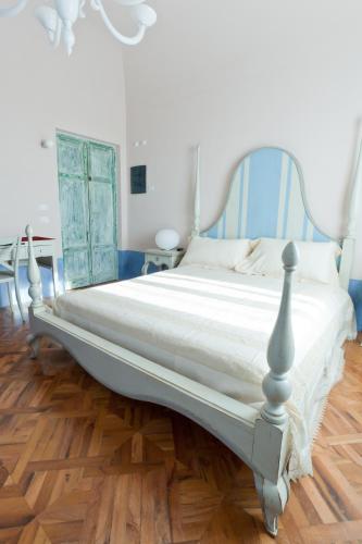 a large bed in a room with a wooden floor at Hotel & Resort Lunatenuta in Mondragone
