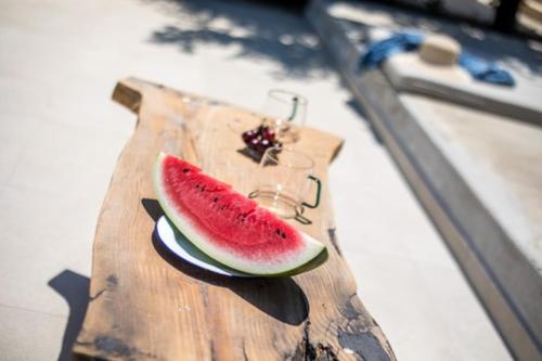 a slice of watermelon on a wooden cutting board at Villa Kora in Kallithea Rhodes