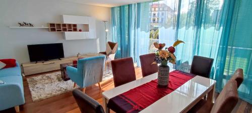 a living room with a table and chairs and a television at Lindas Holiday Apartment in Funchal