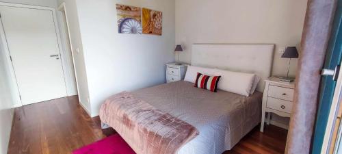a small bedroom with a bed and a dresser with a lamp at Lindas Holiday Apartment in Funchal