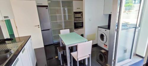 a kitchen with a table and a washing machine at Lindas Holiday Apartment in Funchal