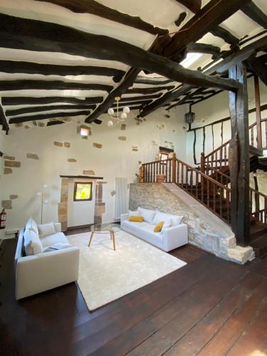 a living room with two white couches and a staircase at Posada La Lomba in Hermosa