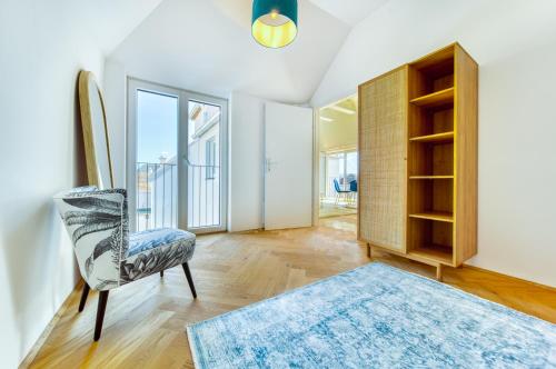 sala de estar con silla y ventana grande en Smile Apartments Burggasse, en Krems an der Donau