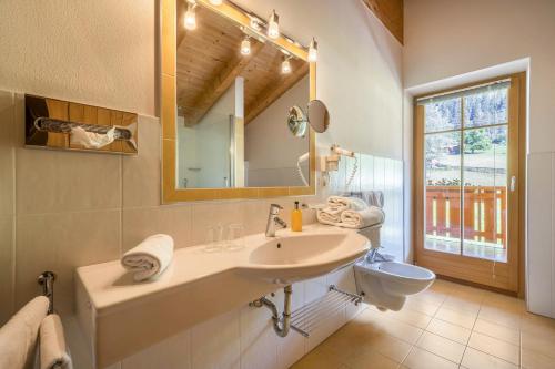 W łazience znajduje się umywalka, lustro i toaleta. w obiekcie Naturresidenz Theistadl Apt 302 w mieście Pracupola