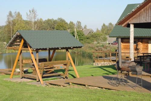 einen Pavillon mit einem Dach neben einem See in der Unterkunft Tatra Holiday House in Tatra