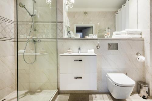 y baño con ducha, aseo y lavamanos. en Uroczy Apartament No1 w ,, SERCU Starego Miasta Wyspa Spichrzów,, en Gdansk