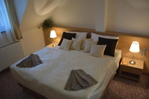 a bedroom with a large bed with two lamps at Hotel Zámek Velká Bystřice in Velká Bystřice