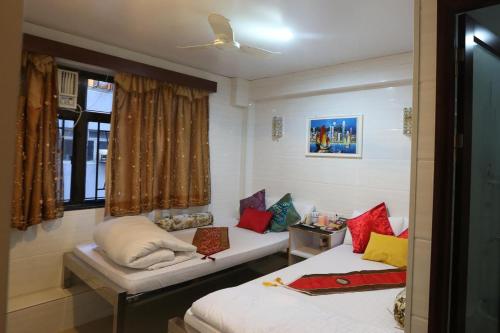 een kamer met 2 bedden en een raam bij Om Guest House in Hong Kong