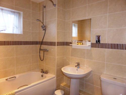La salle de bains est pourvue d'un lavabo, de toilettes et d'une douche. dans l'établissement Wainstones Hotel, à Stokesley