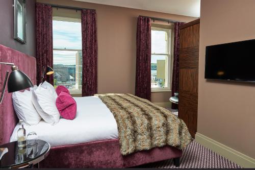 a hotel room with a bed and a large window at Malmaison Dundee in Dundee