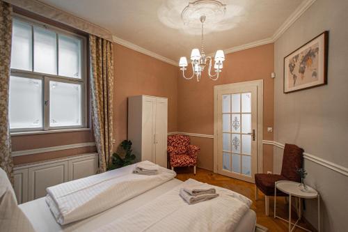 - une chambre avec 2 lits et un lustre dans l'établissement Luxury Central 150m2 Apartment on Wencelas Square with Private Garage, à Prague