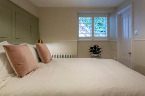 a bedroom with a large white bed with pink pillows at Number 40 in Kingsbridge