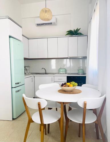 a white kitchen with a white table and chairs at Casa Chara in Symi