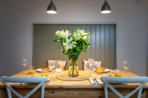 a dining room table with a vase of flowers at Number 40 in Kingsbridge