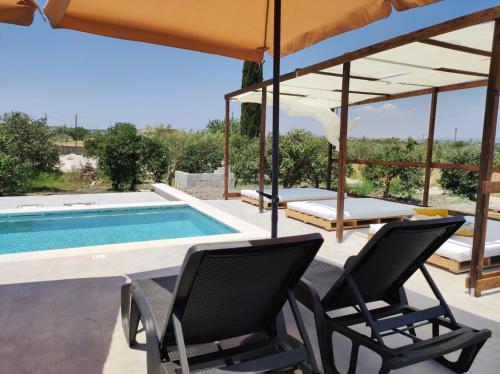 a patio with chairs and a swimming pool at AgriBarocco in Noto