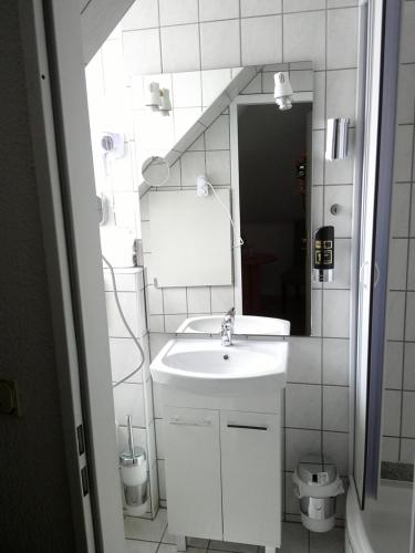 a white bathroom with a sink and a mirror at Hotel Goldenes Lamm in Idstein