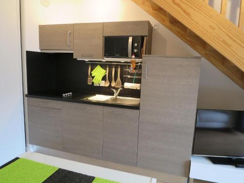 une cuisine avec un évier et un micro-ondes dans l'établissement LES BALCONS DE L'OCEAN, à Biscarrosse-Plage