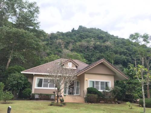 a house with a mountain in the background at Arantarakiri Resort Khao Yai in Mu Si