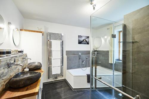 a bathroom with a glass shower and a tub at Haus Kohlpointner in Oberwössen