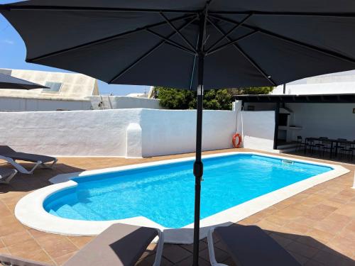un ombrellone nero seduto accanto alla piscina di Nazaret Villa with heated pool a Nazaret