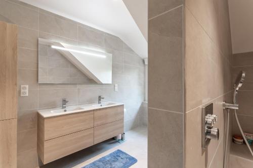une salle de bain avec un lavabo et un miroir dans l'établissement Le Refuge Marin - Gîte familial au bord de mer, à Lamballe
