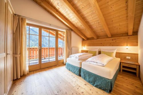 a bedroom with two beds and a large window at Naturresidenz Theistadl Apt 301 in Pracupola