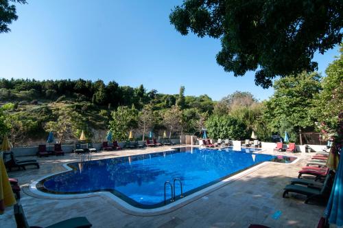 a large swimming pool with chairs and a resort at Fener Motel in Sile