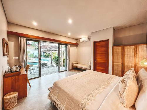 a bedroom with a bed and a sliding glass door at Kalia Bingin - Adult only in Uluwatu