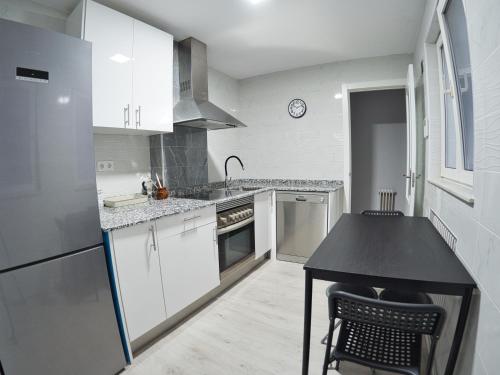 a kitchen with white cabinets and a black counter top at Bonito piso Villafria in Oviedo