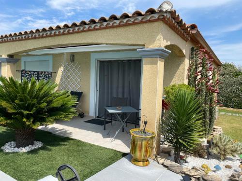 a patio of a house with a table and plants at Chambre avec charme in Garons