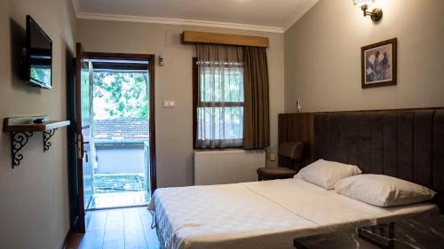 a bedroom with a bed and a window and a door at Fener Motel in Şile