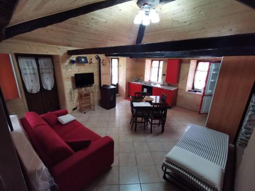 a living room with a red couch and a table at Appartamento Curnet in Balme