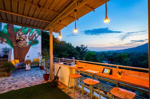 a bar on a balcony with a tree mural at Zostel Rishikesh, Laxman Jhula in Rishīkesh