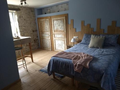 a bedroom with a bed with a wooden headboard at La grange aux dîmes in Walcourt