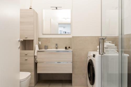 een badkamer met een wasmachine en een wastafel bij Duomo Apartment - Diaz in Milaan
