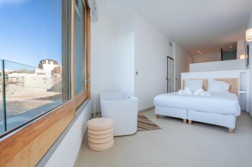 biała sypialnia z łóżkiem i oknem w obiekcie CASA UMI - Magnifique appartement avec accès privé à la mer et grande terrasse w Marsylii
